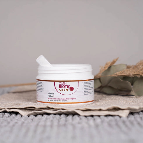 Eine offene Packung OMNi-BiOTiC SKiN Intensiv-Fußbad auf einem Handtuch