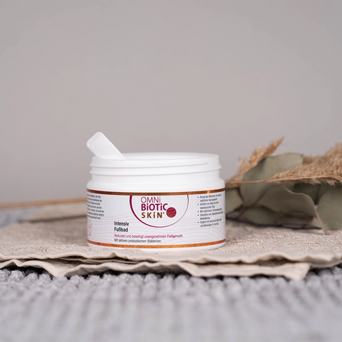 Eine offene Packung OMNi-BiOTiC SKiN Intensiv-Fußbad auf einem Handtuch