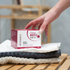 Eine Hand greift nach einer Packung OMNi-BiOTiC SKiN Intensiv-Hautbad