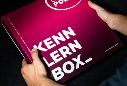 Eine Person hält eine OMNi-POWER-KENN-LERN-BOX
